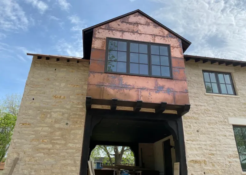 Copper metal panel facade on a stone building for Roof Repair in Oakley